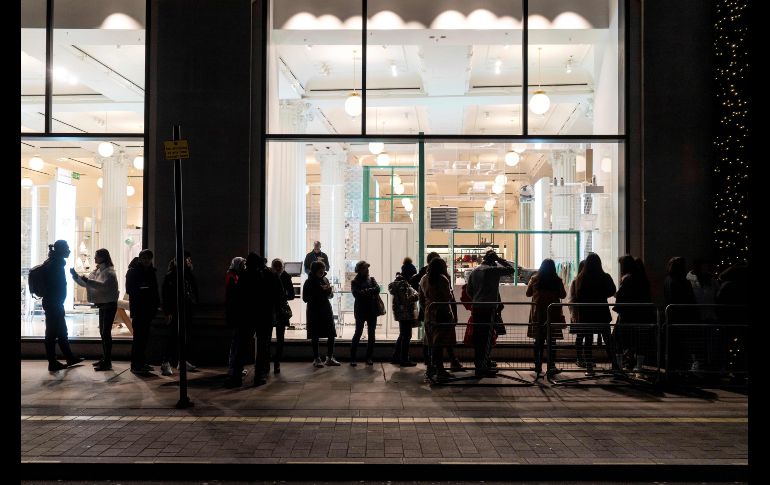Consumidores hacen fila antes de la apertura de una tienda departamental. AFP/N. Halle