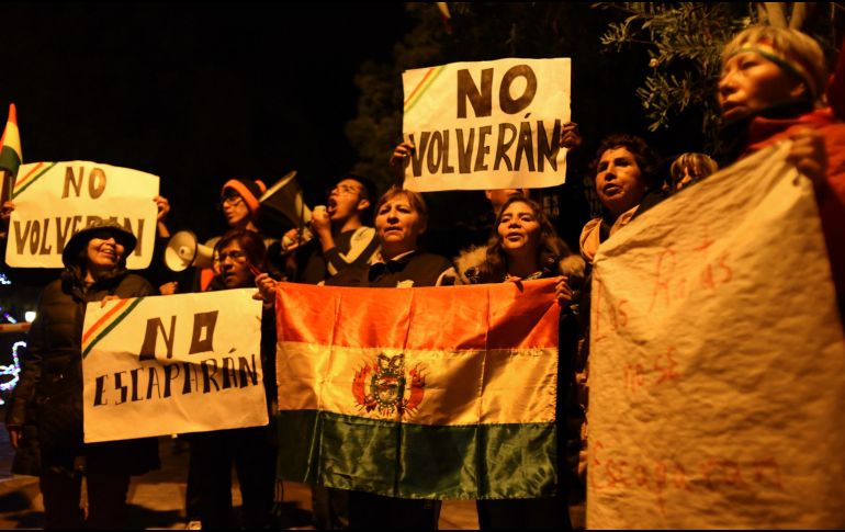 Manifestantes protestan afuera de la residencia de la embajadora de México con banderas y carteles contra funcionarios del anterior gobierno boliviano. AP/L. Gandarillas