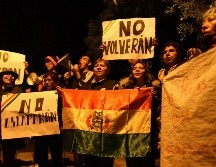 Manifestantes protestan afuera de la residencia de la embajadora de México con banderas y carteles contra funcionarios del anterior gobierno boliviano. AP/L. Gandarillas