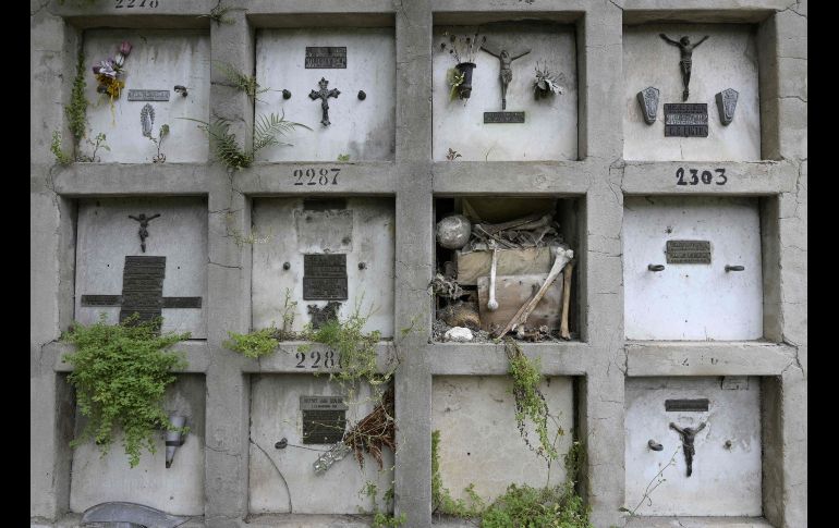 Restos humanos quedan a la vista en un nicho dañado en el panteón público Chacarita, en Buenos Aires.