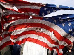 Un manifestante rompe una bandera estadounidense durante una manifestación multitudinaria contra EU en Teherán, después de que el Pentágono reivindicase el bombardeo selectivo que acabó con la vida de Qasem Soleimaní. EFE / A. Taherkenareh