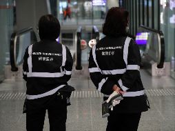 Oficiales de salubridad con escáneres de temperatura en el aeropuerto de Hong Kong. AP/A. Wong