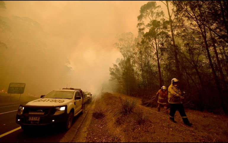 Bomberos combaten el fuego en Moruya, ciudad de la Costa Sur lejana de Nueva Gales del Sur. AFP/P. Parks