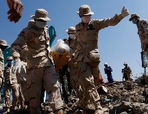Rescatistas cargan el cuerpo de una víctima del inmueble colapsado en Kep. EFE/EPA/M. Remissa