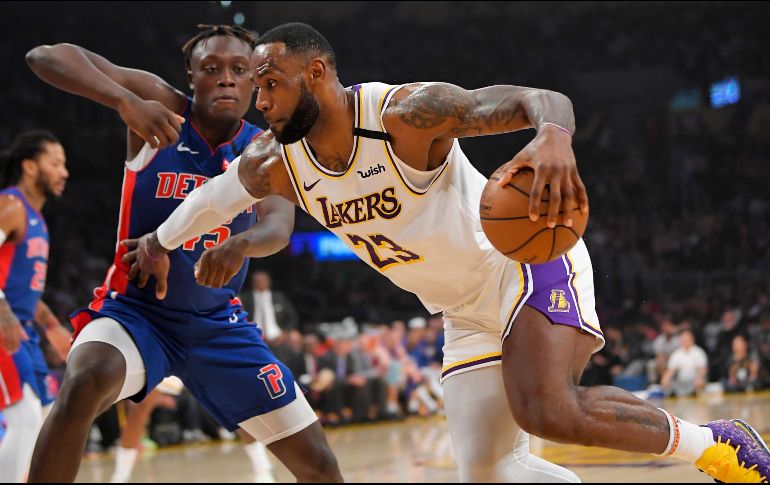 LeBron James pasa al delantero de los Detroit Pistons, Sekou Doumbouya, durante la primera mitad de un partido de baloncesto de la NBA el domingo. AP / M. J. Terrill
