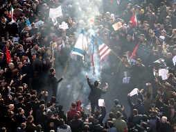 Habitantes incendian banderas de Estados Unidos e Israel durante la procesión funeraria de Soleimani en Teherán. AFP/A. Kenare