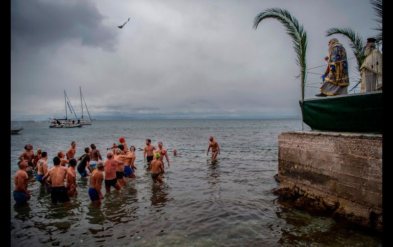 Fieles intentan atrapar una cruz arrojada al mar en Atenas, Grecia, durante la celebración de la Epifanía ortodoxa. AFP/A. Tzortzinis