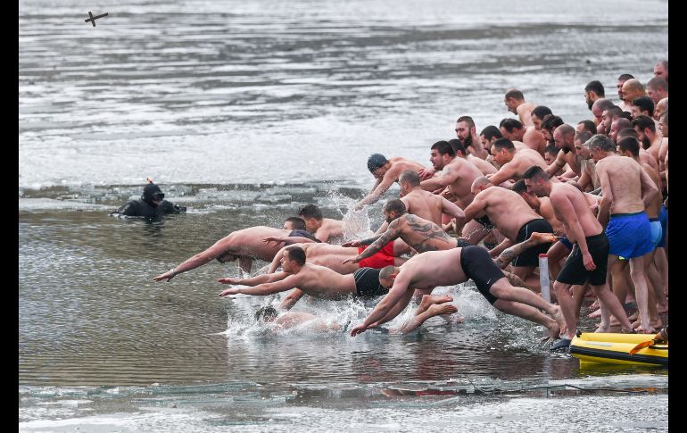Hombres se lanzan a un lago en Sofía, Bulgaria. AFP/N. Doychinov
