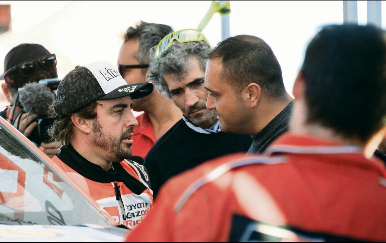 Retraso. Alonso (izq.) y su copiloto Marc Coma tardaron cerca de dos horas y media para reparar la avería, lo que ocasionó que se relegaran en la clasificación general. AFP • F. Fife
