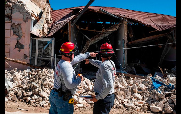 Bomberos evalúan los daños en un edificio en Guánica. Una serie de han sacudido la isla durante los pasados días. AFP/R. Arduengo