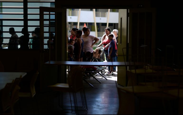 Personas evacuadas de viviendas con daños hacen fila en para recibir alimentos en un refugio en Ponce. Los sismos dejaron daños en las líneas eléctricas y en algunas zonas aún no se restablece la energía.  AP/C. Giusti