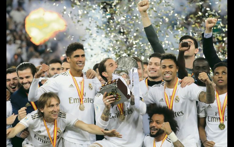 EUFÓRICOS. Los jugadores madridistas celebran su nueva conquista en tierras sauditas, mientras Sergio Ramos besa la copa. AFP