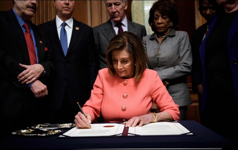 Nancy Pelosi firma los cargos para el juicio político contra Trump. AFP/B. Smialowski