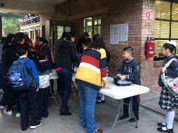 Aspectos de la reanudación de las clases en el Colegio Cervantes, de Torreón; alumnos cruzan arcos detectores de metal. SUN