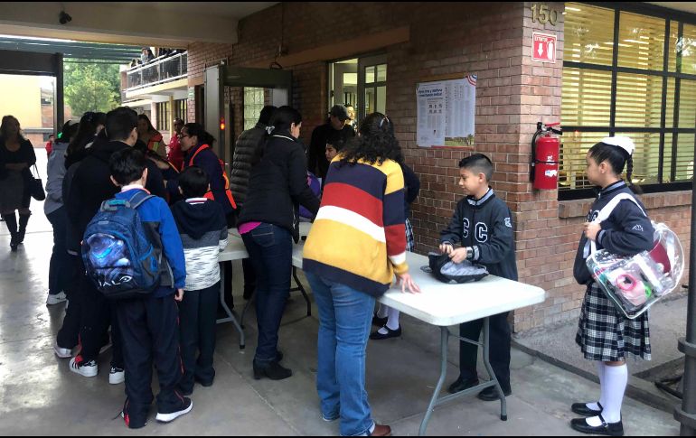 Aspectos de la reanudación de las clases en el Colegio Cervantes, de Torreón; alumnos cruzan arcos detectores de metal. SUN
