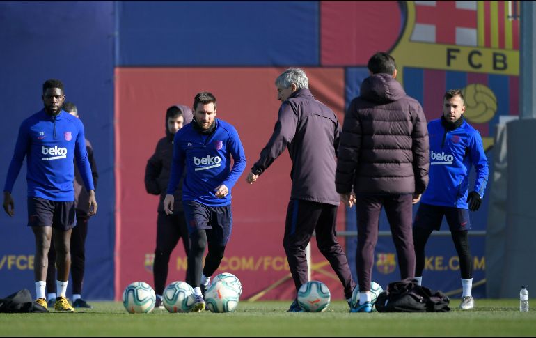 En la práctica de ayer, Setién intercambió conceptos con Messi. AFP/L. Gene
