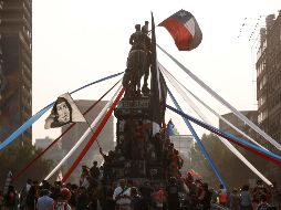 Manifestantes protestan en lo alto del monumento al general Manuel Baquedado, héroe de la guerra del Pacífico (1879-1884). EFE