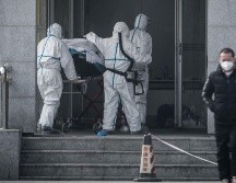 Personal médico traslada a un paciente al hospital Jinyintan, donde se atiende a los infectados con la nueva cepa de coronavirus, en Wuhan. AFP