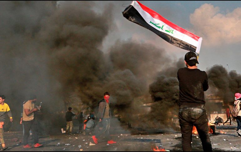Un manifestante ondea la bandera iraquí durante las movilizaciones en Bagdad. AP/H. Mizban