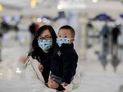 Viajeros usan cubrebocas en el aeropuerto internacional Daxing en Pekín. AFP/N. Asfouri