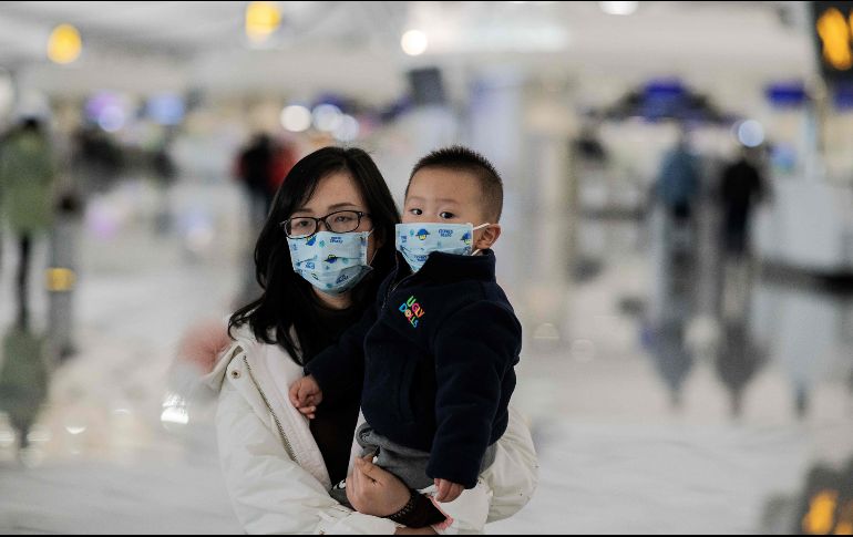 Viajeros usan cubrebocas en el aeropuerto internacional Daxing en Pekín. AFP/N. Asfouri