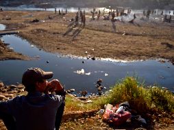 Un centroamericano descansa junto al Suchiate, del lado de Ciudad Hidalgo, Chiapas. Migrantes que cruzaron el río desde Guatemala pasaron ahí la noche en espera de que autoridades les permitan adentrarse por México. AFP/A. Estrella
