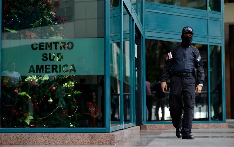 Oficiales de seguridad bloquean la entrada del edificio donde se encuentran las oficinas del líder opositor venezolano, Juan Guaidó, en Caracas. AP