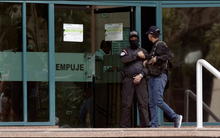 Oficiales de seguridad bloquean la entrada del edificio donde se encuentran las oficinas del líder opositor venezolano, Juan Guaidó, en Caracas. AP