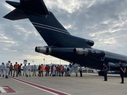 La Guardia Nacional vigila a hondureños al abordar una aeronave para regresar a su país. EFE/Segob