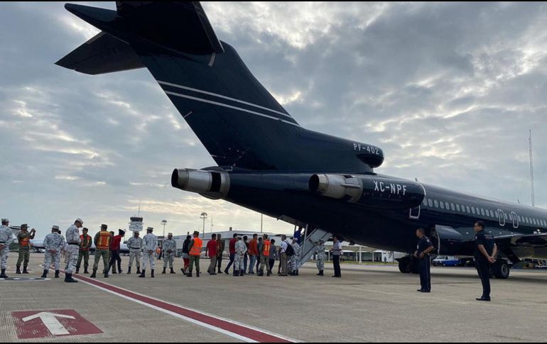 La Guardia Nacional vigila a hondureños al abordar una aeronave para regresar a su país. EFE/Segob
