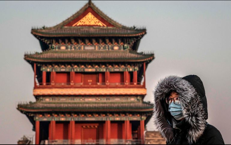 Una mujer con mascarilla en Pekín. A las autoridades les preocupa el masivo movimiento de viajeros por las vaciones del Año Nuevo chino, que arrancan este viernes. AFP/N. Asfouri