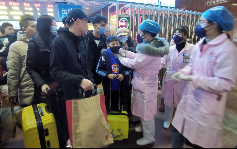 Personal médico revisa la temperatura de pasajeros que llegan a la estación de trenes de Yingtan, China. EFE/EPA/Hu Guolin
