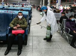 Un operario desinfecta una zona de espera para pasajeros en la estación de tren de Nanchang, en la provincia china de Jiangxi. EFE/EPA/Hu Guolin