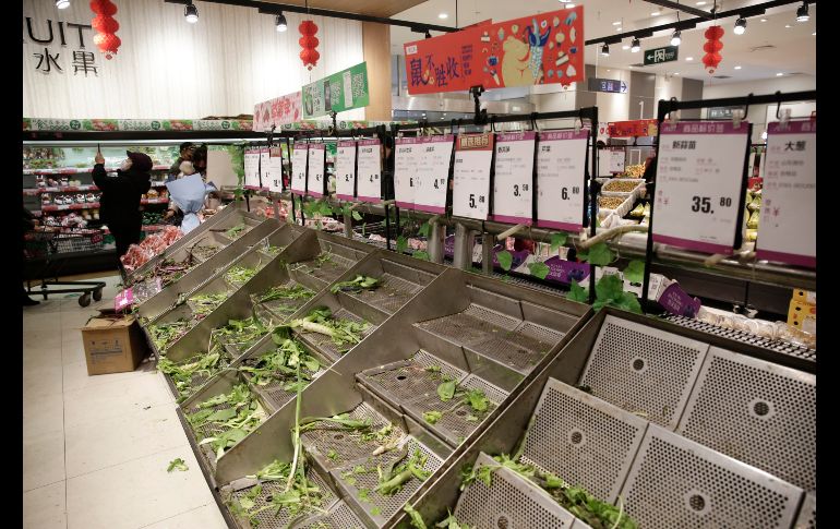 Espacios para vegetales lucen sin producto en un mercado, pues consumidores se han apresurado a avituallarse. EFE