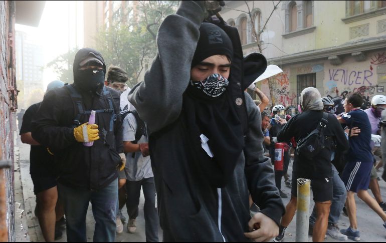 Manifestantes se enfrentan a las Fuerzas Especiales de Carabineros este viernes en los alrededores de la Plaza Italia, en Santiago. EFE/A. Valdéz