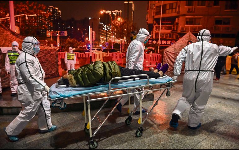 Prisa. Socorristas trasladan a un paciente a un hospital de la Cruz Roja en Wuhan. AFP