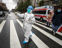 Un trabajador en atuendo protector especial dirige hoy a pacientes a un hospital en Wuhan. AP/Chinatopix