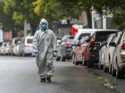 Un trabajador del sector salud camina hoy por una calle de Wuhan. La ciudad está en cuarentena, por lo que no hay transportes para salir ni llegar a ella. AP/Chinatopix