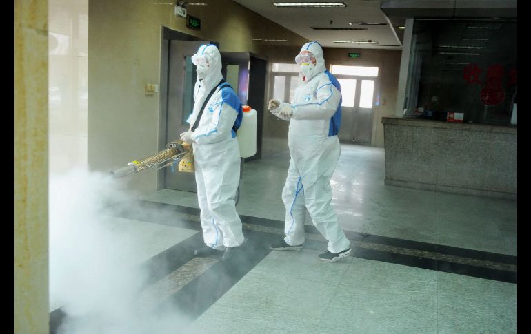 Autoridades chinas despliegan equipos para desinfectar calles, barrios y otros lugares públicos como medida de contención del brote de coronavirus. Voluntarios desinfectan en Qingdao. EFE/EPA