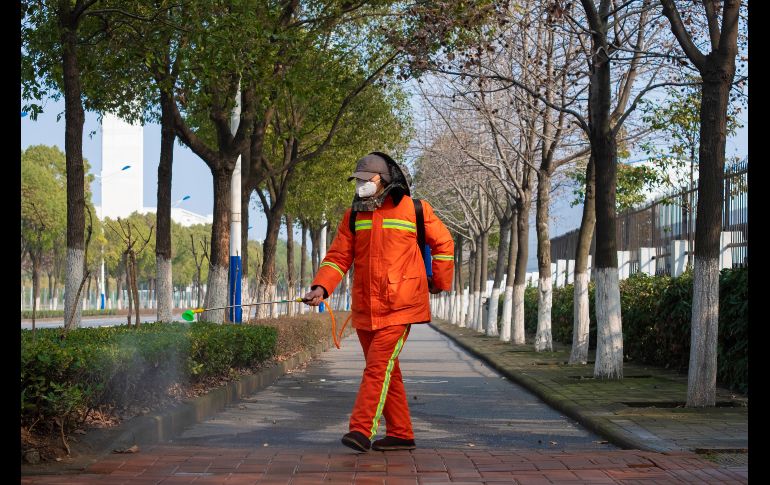Un trabajador con un traje protector especial rocía desinfectante en una calle de Wuhan. La enfermedad ha dejado hasta ahora 106 muertos y más de cuatro mil 500 infectados en China. AP/A. Rataj