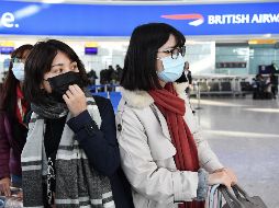Viajeras usan cubrebocas en el aeropuerto de Heathrow, en Londres. British Airways anunció este miércoles la suspensión inmediata de todos sus vuelos desde y hacia China. EFE/EPA/A. Rain
