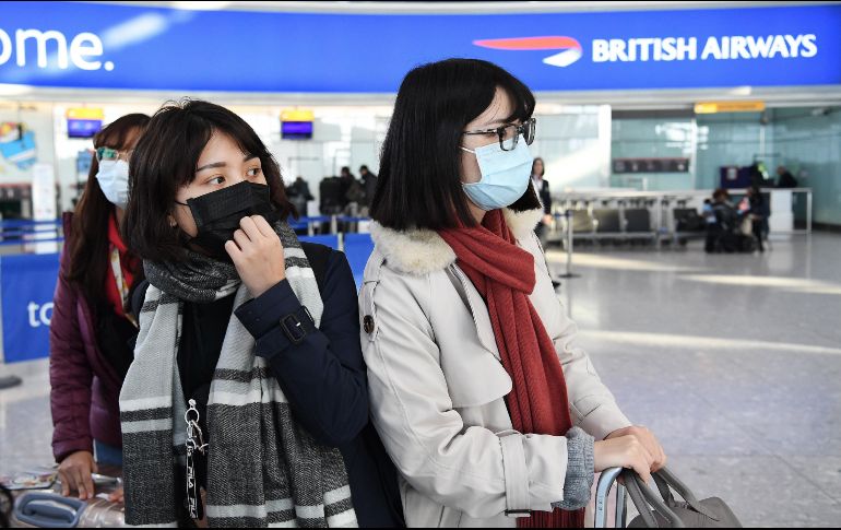 Viajeras usan cubrebocas en el aeropuerto de Heathrow, en Londres. British Airways anunció este miércoles la suspensión inmediata de todos sus vuelos desde y hacia China. EFE/EPA/A. Rain