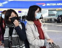 Viajeras usan cubrebocas en el aeropuerto de Heathrow, en Londres. British Airways anunció este miércoles la suspensión inmediata de todos sus vuelos desde y hacia China. EFE/EPA/A. Rain