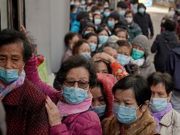 Personas hacen fila hoy para comprar mascarillas en una tienda en  Hong Kong. AP/Kin Cheung