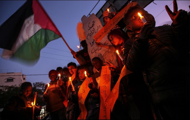 Niños palestinos sostienen velas durante una protesta contra el llamado 