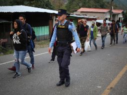 Policías verifican los antecedentes de los migrantes en Agua Caliente, Honduras. EFE/G. Amador