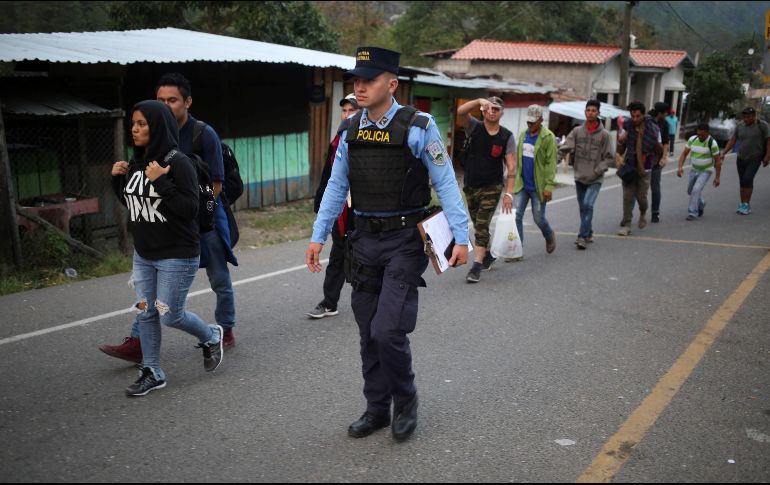 Policías verifican los antecedentes de los migrantes en Agua Caliente, Honduras. EFE/G. Amador