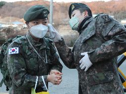 Un centinela le toma la temperatura a un soldado a la entrada de una unidad del Ejército como parte de las acciones para evitar la propagación del coronavirus en la ciudad de Goyang, Corea del Sur. EFE/YONHAP