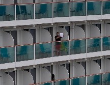 Un pasajero muestra un texto desde el crucero World Dream en Hong Kong, luego de que autoridades pusieron a la embarcación en cuarentena para prevenir el contagio del coronavirus. AP/V. Yu
