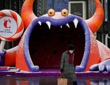 Una mujer con una mascarilla camina junto a un centro comercial en Pekín. AFP/W. Zhao